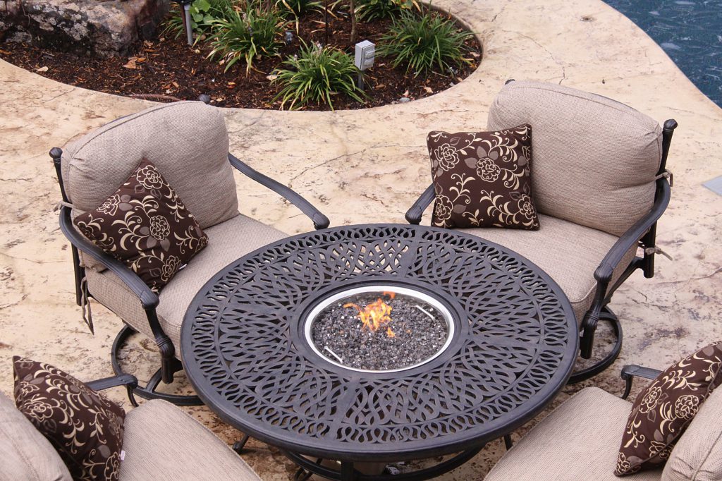 Outdoor lounge furniture with fire pit in table and chairs surrounding